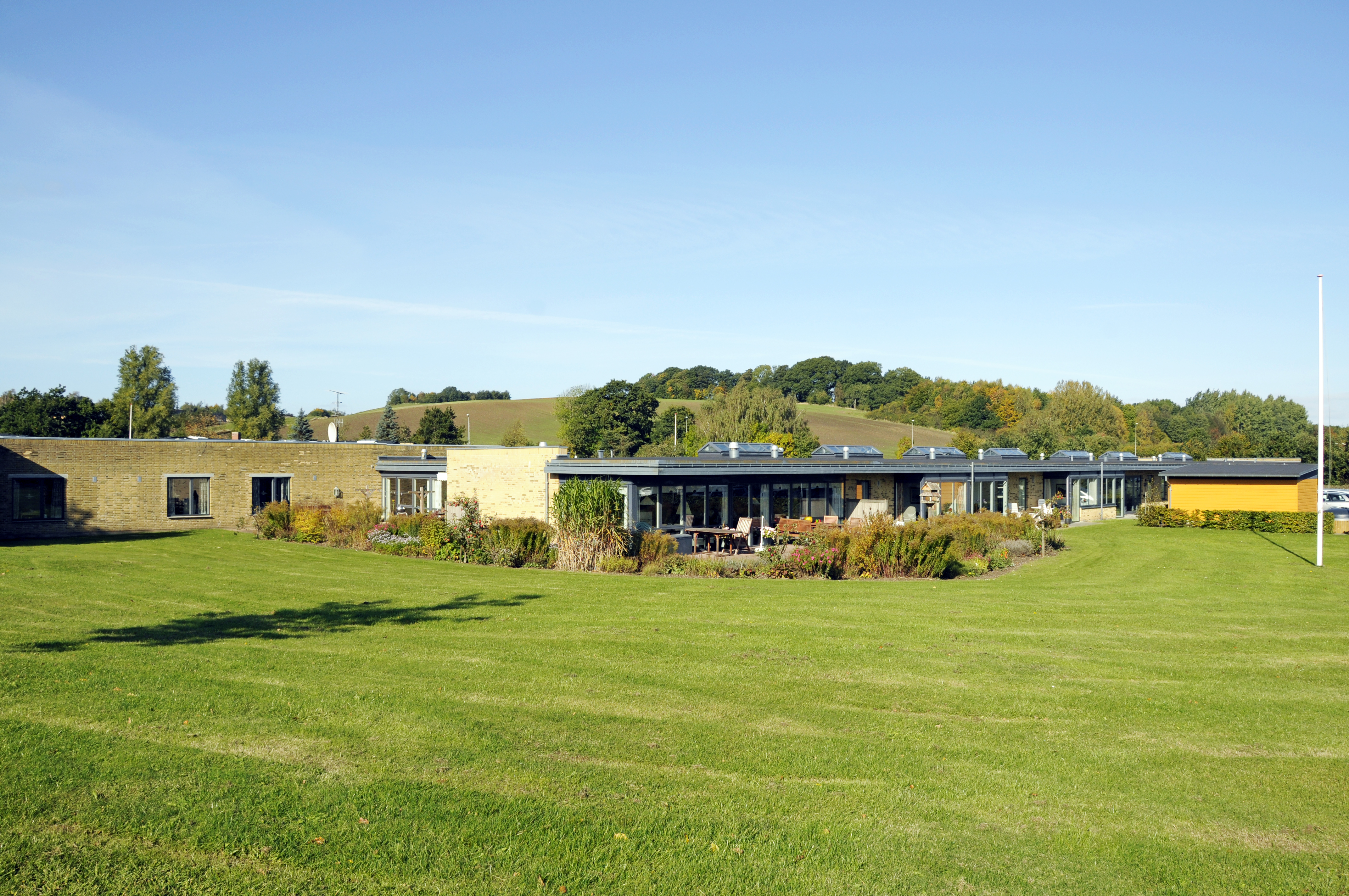 Have med græsplæne og flagstang hos Kildevang